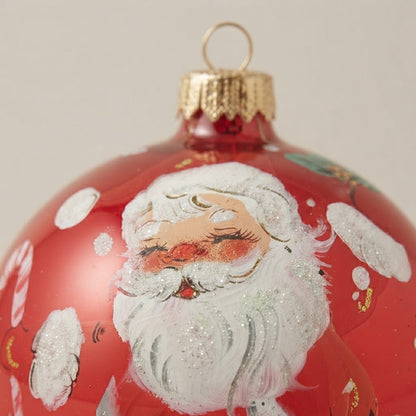 Dettaglio del decoro dipinto a pennello: Babbo Natale sotto la neve su fondo rosso