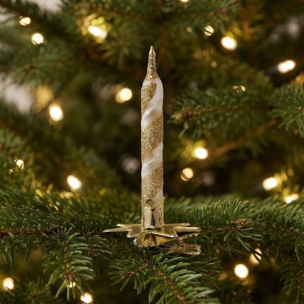 Candelina bianca e oro agganciata ai rami dell'albero di Natale