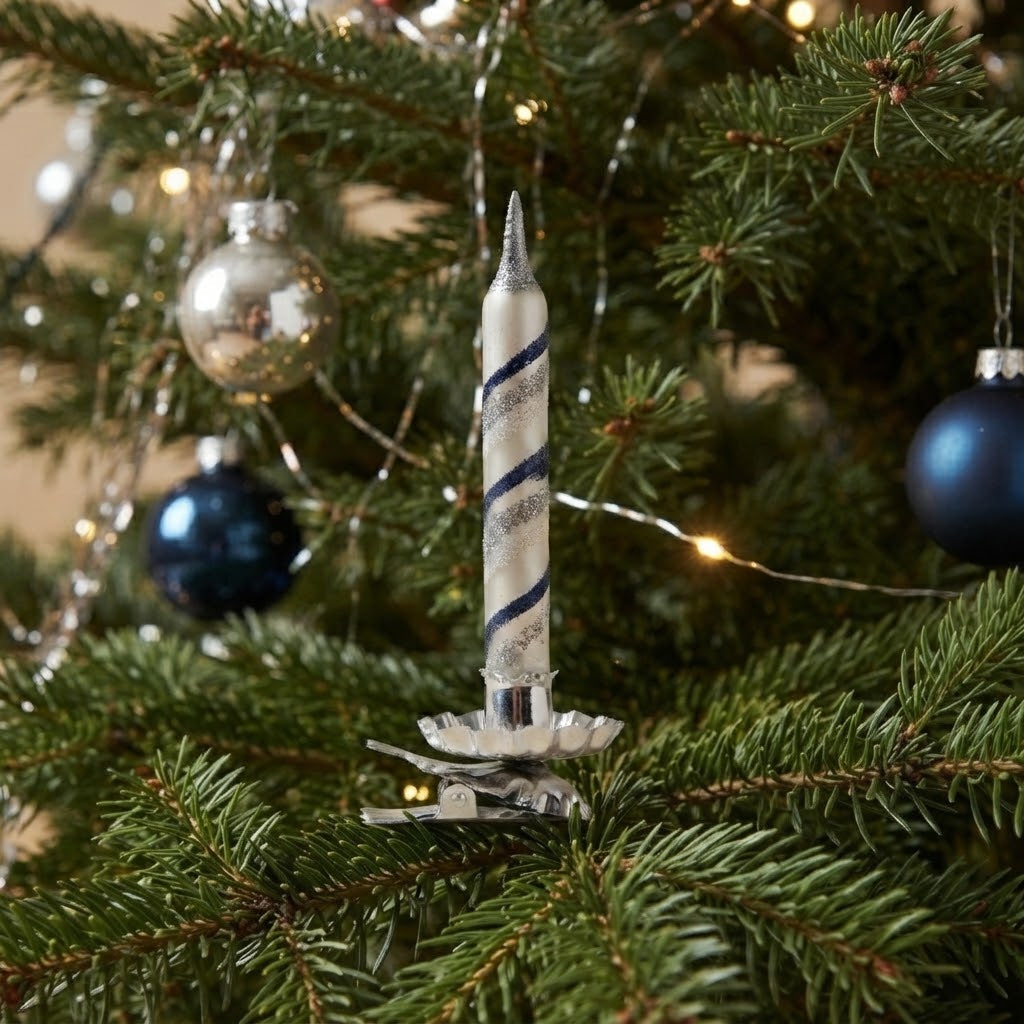 Candelina bianca e blu agganciata ai rami dell'albero di Natale