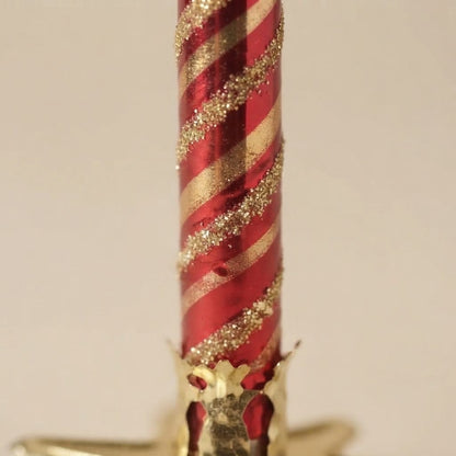 Dettaglio delle righe oro e del glitter sul rosso a specchio
