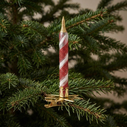 Candelina rossa e oro agganciata a un ramo dell'albero di Natale
