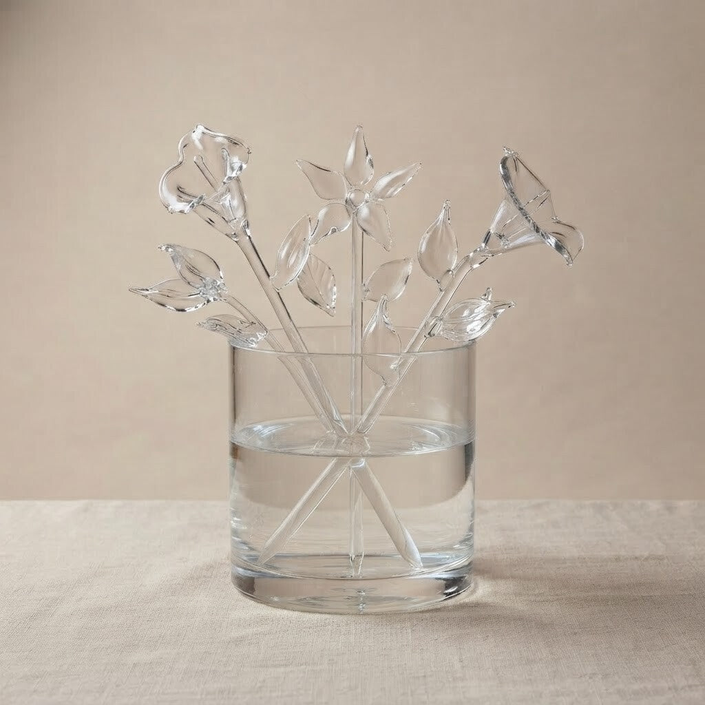 Composizione di fiori in vetro trasparente in un vaso: campanula, giglio, calla e rami con foglie
