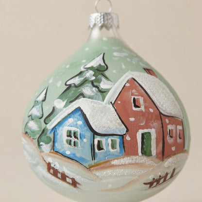 Decoration detail: Christmas drop ornament with a snowy village on green