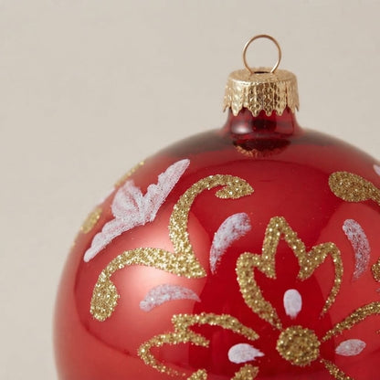 Dettaglio dell'arabesco oro e bianco su rosso lucido