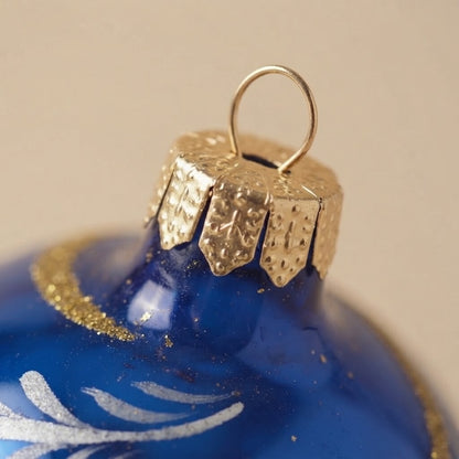 Dettaglio ravvicinato: palla di Natale blu con volute oro e bianche, Ø 10 cm