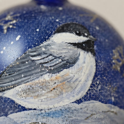 Decoration detail: Christmas ornament with a chickadee on blue, 4 in (10 cm)