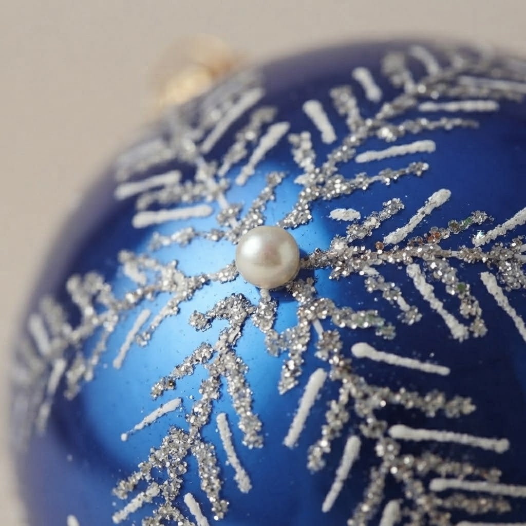 Close-up of the brush-painted decoration: Christmas ornament with silver snowflake on blue