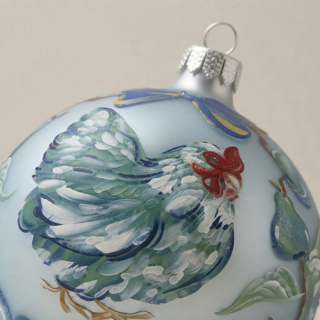 Close-up of the brush-painted decoration: Christmas ornament with hen and flowers on light blue