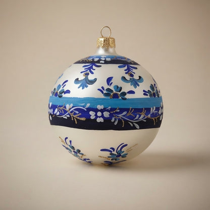 Palla di Natale Ø 10 cm dipinta a mano in stile maiolica: fasce azzurre e blu con motivi floreali su fondo bianco