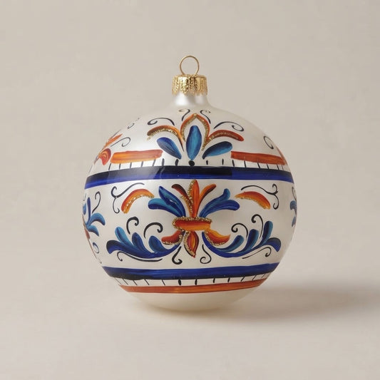 Palla di Natale Ø 10 cm dipinta a mano in stile maiolica: fasce blu e arancio con gigli stilizzati su fondo bianco