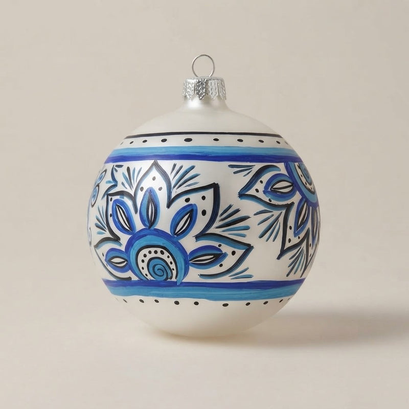 Palla di Natale Ø 10 cm dipinta a mano in stile maiolica: rosoni blu e azzurri tra fasce e puntini su fondo bianco