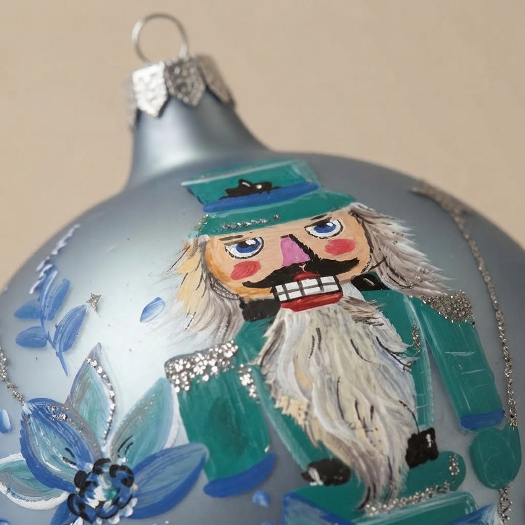 Close-up of the brush-painted decoration: Christmas ornament with nutcracker and blue flowers