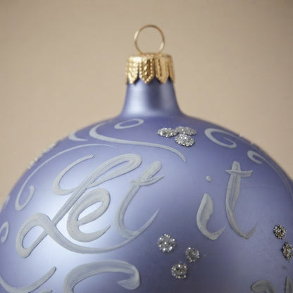 Dettaglio del decoro: palla di Natale scritta Let it snow su lilla, Ø 10 cm