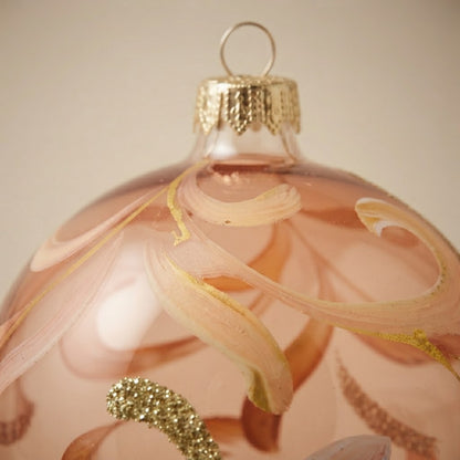 Dettaglio delle volute rosa e del glitter oro