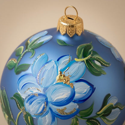 Dettaglio del decoro dipinto a pennello: grande fiore azzurro e foglie su fondo blu