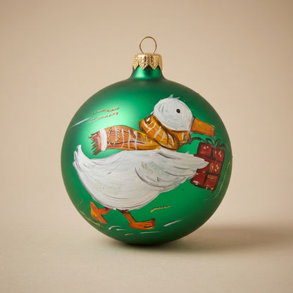 Palla di Natale Ø 10 cm dipinta a mano: papera bianca con sciarpa e regalo su fondo verde