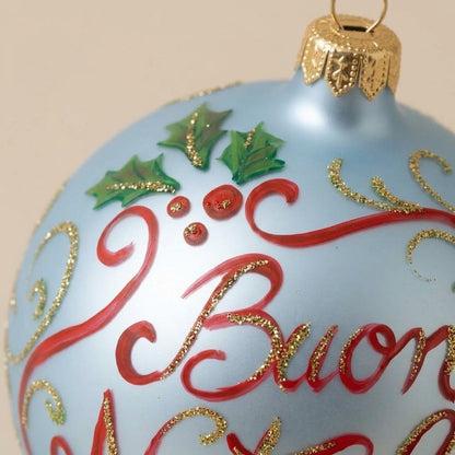 Dettaglio del decoro dipinto a pennello: scritta Buon Natale rossa con agrifoglio su fondo azzurro