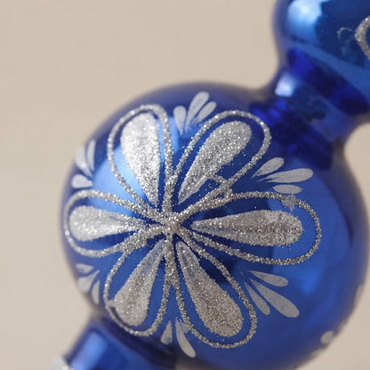 Dettaglio del fiore in glitter argento sulla sfera blu