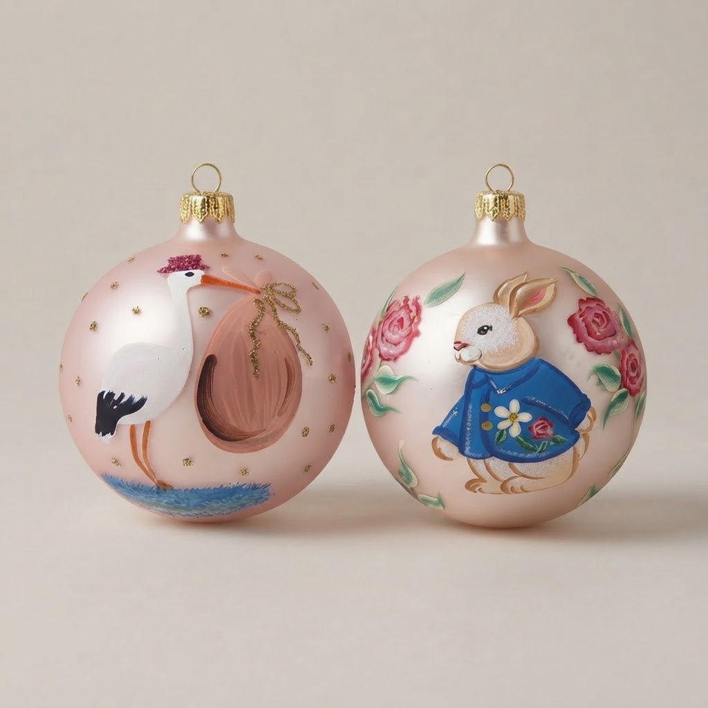 Set da 2 palle di Natale con una cicogna e un coniglietto su fondo rosa, dipinte a mano