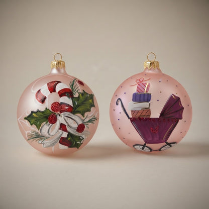 Set da 2 palle di Natale con un bastoncino di zucchero e una carrozzina su fondo rosa, dipinte a mano