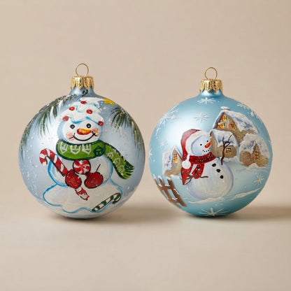 Set da 2 palle di Natale con due pupazzi di neve su fondo azzurro, dipinte a mano