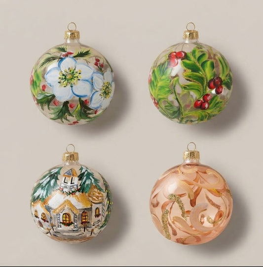 Set da 4 palle di Natale su vetro trasparente: rose di Natale, pungitopo, chiesetta tra gli abeti e volute cipria